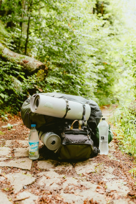Una mochila tirada al costado de un camino de tierra.