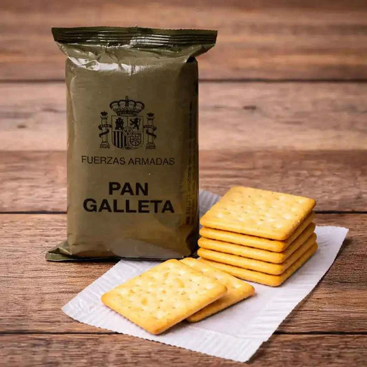Bolsa de pan galleta militar y galletas cuadradas doradas apiladas sobre papel