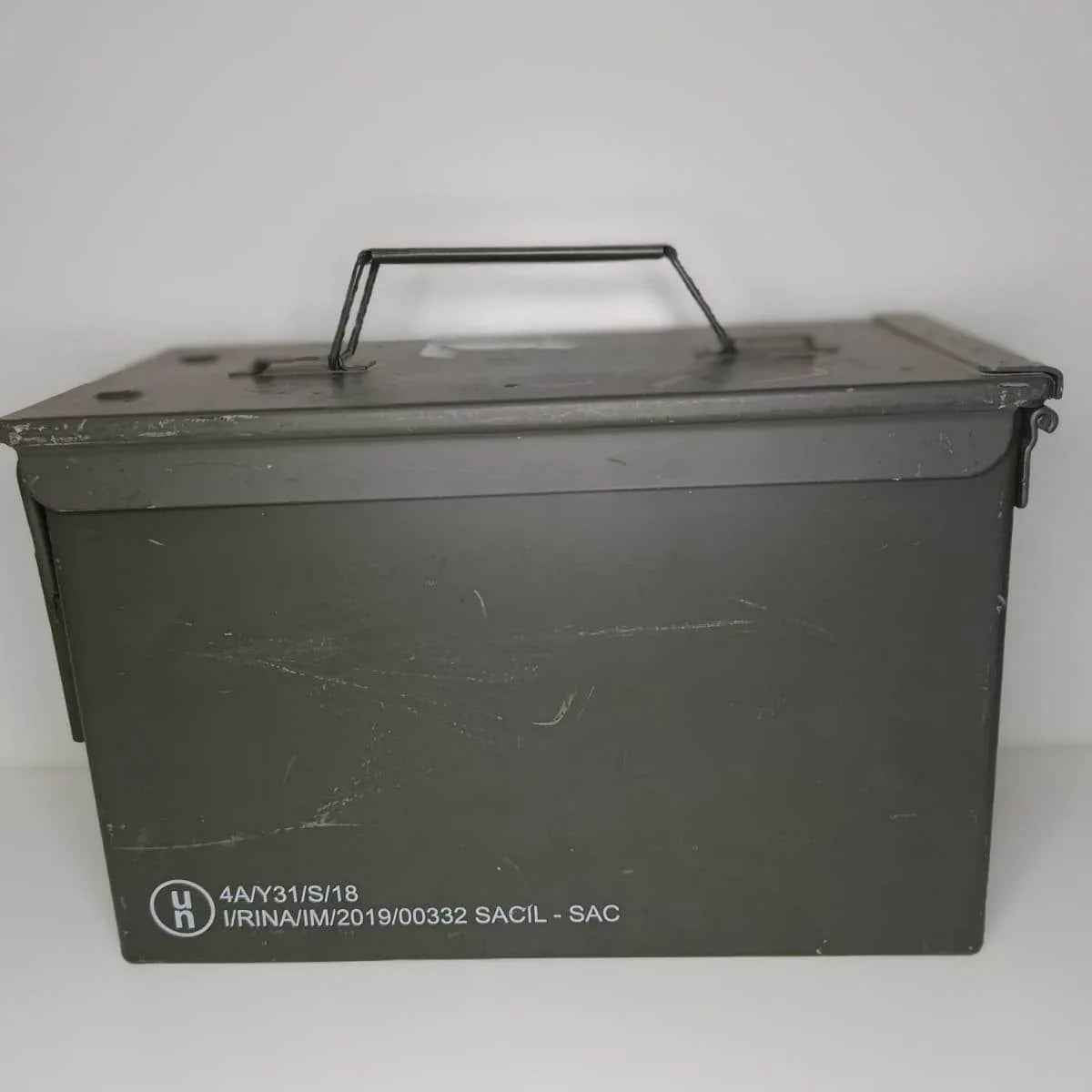 Caja de munición estanca verde con asa superior y marcas en la tapa