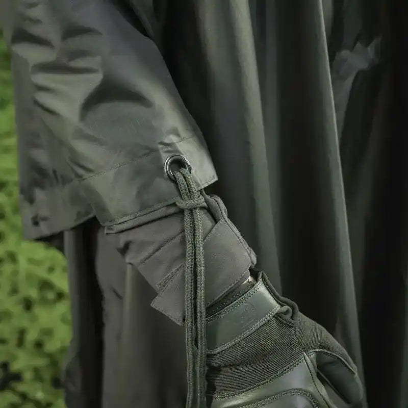 Poncho de lluvia militar M-Tac con ojal metálico y cordón de sujeción en color verde oliva.